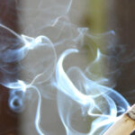 Image of a lit cigarette exuding smoke.