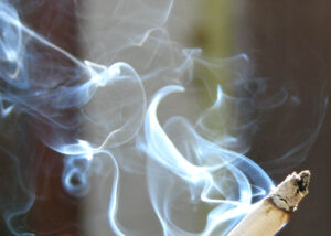 Image of a lit cigarette exuding smoke.