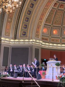 Honorees on a stage under a large dome during a ceremony