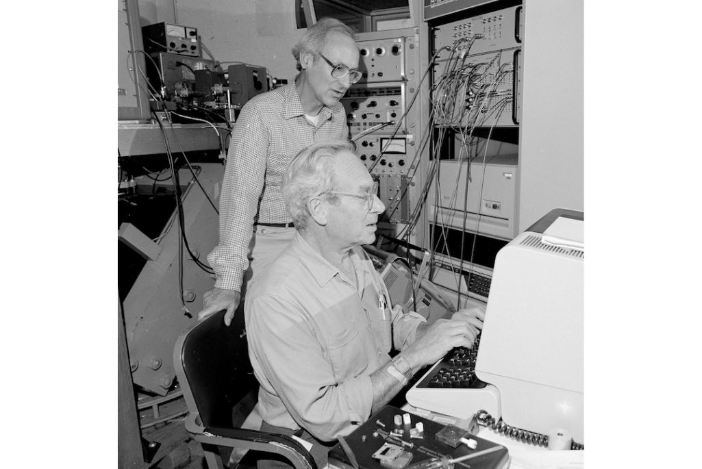 Black and white photo of two men, Melvin Klein and Kenneth Sauer, working together behind a computer.